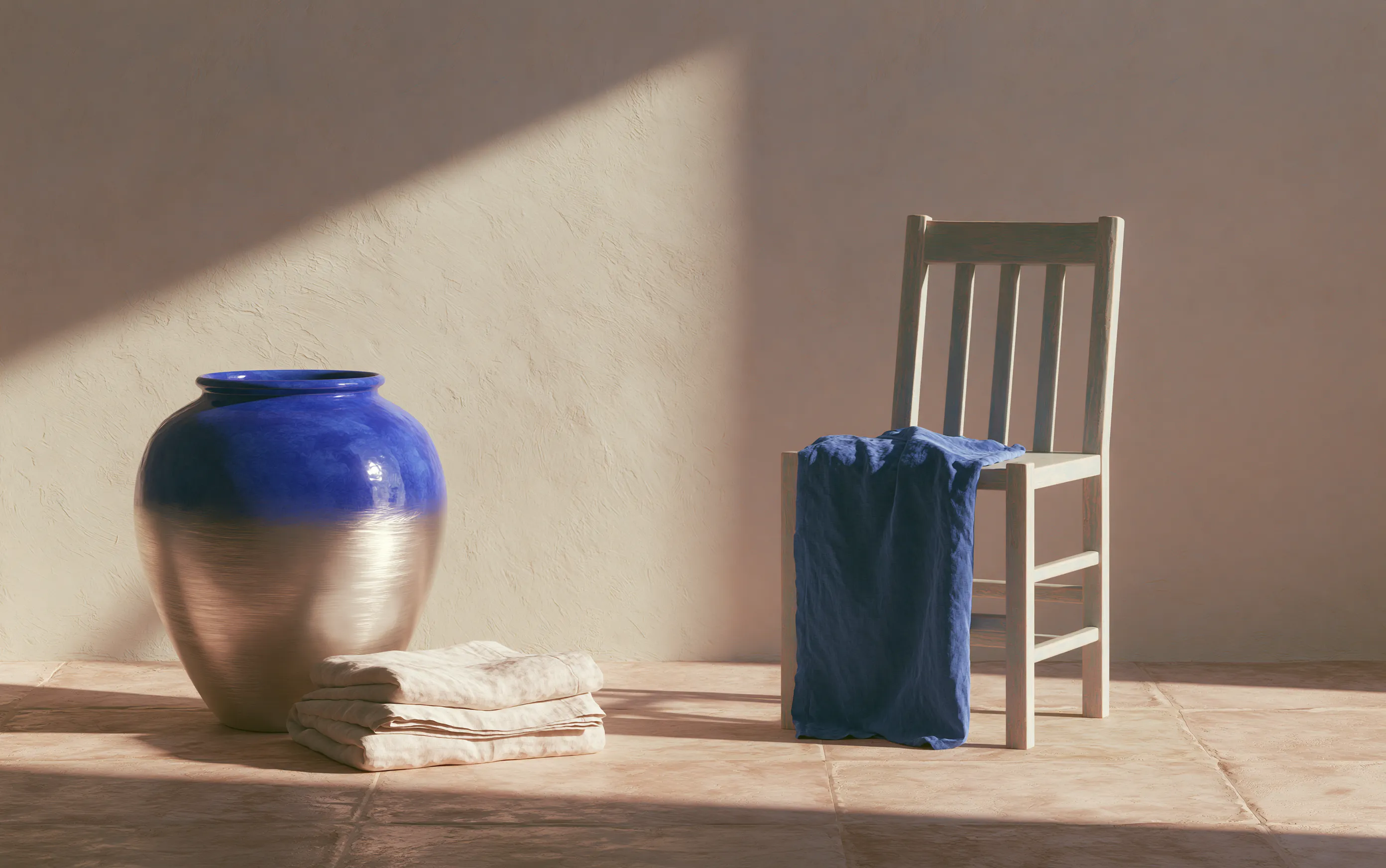 Cobalt vase, folded linen and timber chair in a warm studio still life
